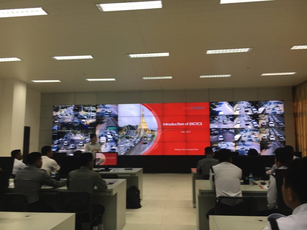 A briefing in a control room, with road cameras on the video wall
