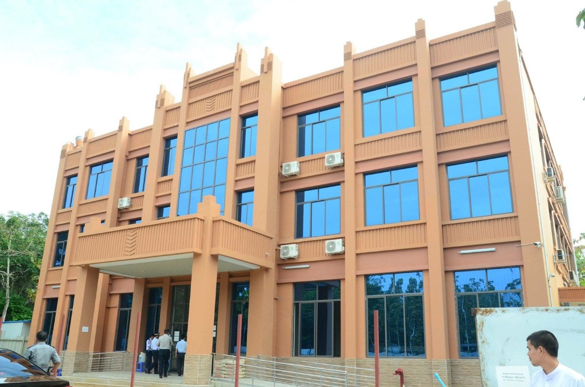 A peach-colored office building with a grid of blue windows
